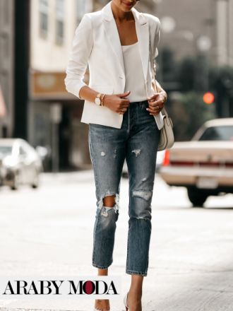 A feminine winter look with a white blazer, heels and ripped jeans