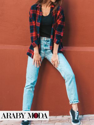 Fall outfit that combines jeans with a black blouse and a classic checkered shirt