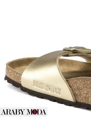 Side view of gold Birkenstock slippers engraved with the logo