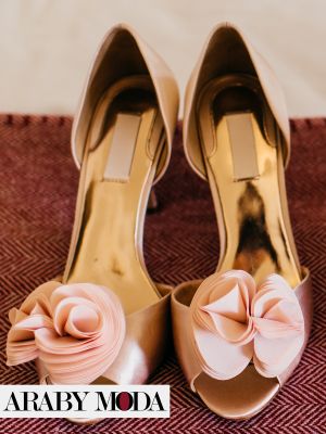 Gold bachelorette heels with a pink rose-shaped bow