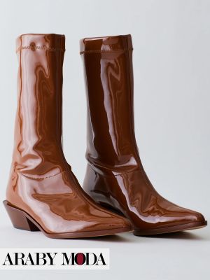 الجلد البني اللامع في البوت الشتوي يعطيه لمسة من الفخامة